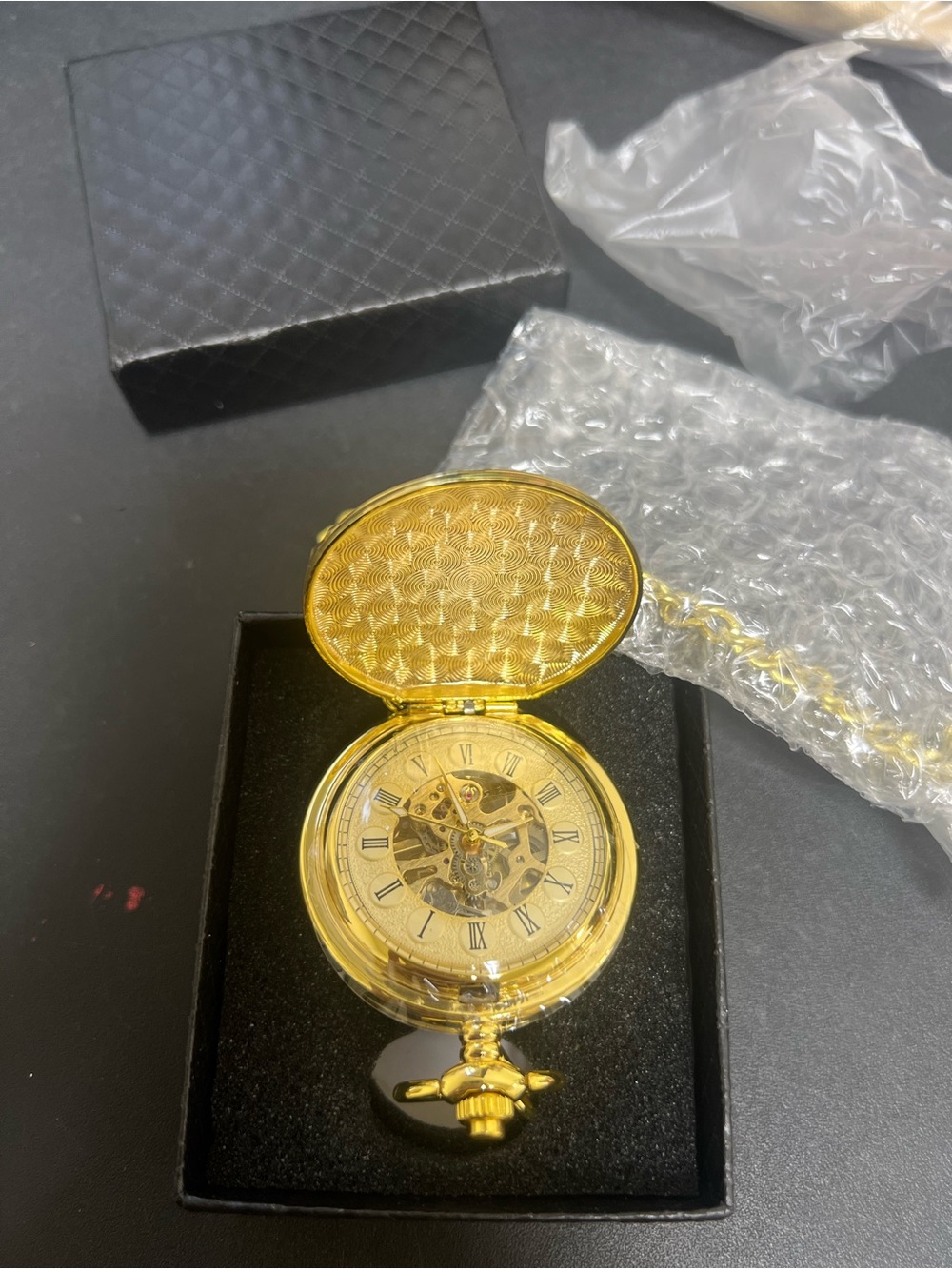 gold-tone mechanical pocket watch featuring an open-face skeleton dial with Roma